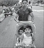  ?? RODRIGO ABD/AP ?? Cristian, a migrant, pushes his children Wednesday as they make the 45-mile journey to Mapastepec, Mexico.