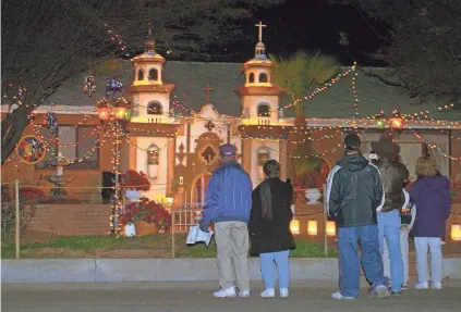  ?? TUCSON CITIZEN ?? Walkers stop to look at one of the many homes decorated for the annual Winterhave­n Festival of Lights in Tucson.
