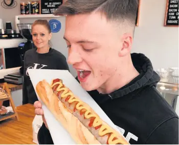  ??  ?? Delicious
Customer Kobi Marco tucks into a feast as Jingers’Jane Hynes looks on