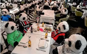  ?? AP ?? Soft toy pandas and bottles of Corona beer decorate the tables of a closed restaurant in Frankfurt. Germany is considerin­g whether to extend a monthlong November lockdown.