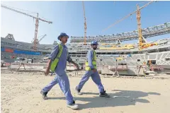  ??  ?? Workers walk inside the Lusail stadium under constructi­on for the 2022 World Cup in Doha, Qatar, in December last year.