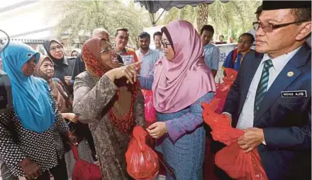  ?? [FOTO ROSDAN WAHID /BH] ?? Fuziah (tengah) dan Mohd Ajib beramah mesra dengan penerima sumbangan selepas melancarka­n JAWI Food Bank di Masjid Jamek Sultan Abdul Samad, Kuala Lumpur, baru-baru ini.