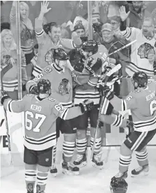  ?? DAVID BANKS, USA TODAY SPORTS ?? The Blackhawks celebrate Ryan Hartman’s goal against the Wild on Oct. 12.