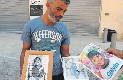  ??  ?? Tahar holds photograph­s of his four-year-old son Kylan at the ar-Rahma mosque in the eastern Nice suburb of Ariane. Kylan and his mother Olfa Kalfallah, 31, were killed in last week’s truck attack.