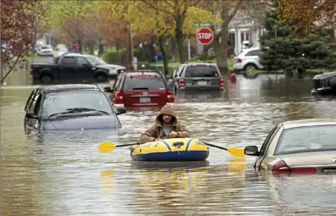  ?? Max Ortiz/Detroit News via AP ?? A Hanover Street resident surveys the damage along Currier Street on Wednesday following flooding in Dearborn Heights, Mich. Overnight rain across the Detroit area lefts scores of basements flooded and made some local streets impassable.