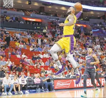  ?? Brynn Anderson Associated Press ?? THE LAKERS’ LeBron James breaks free and scores on a dunk in the first quarter Sunday. James had 28 points by the half, missing only four of his 15 shots and two of his three-pointers.