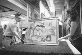  ?? ASSOCIATED PRESS ?? IN THIS AUG. 9 PHOTO provided by the University of Arizona, Willem de Kooning’s “WomanOchre” is readied for examinatio­n by Nathan Saxton, right, an exhibition­s specialist, and Kristen Schmidt, a registrar, in Phoenix. More than three decades after...