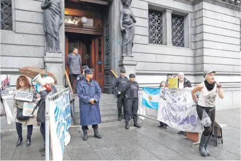  ??  ?? ► Un grupo de personas protesta afuera de la sede del Congreso, ayer en Buenos Aires.