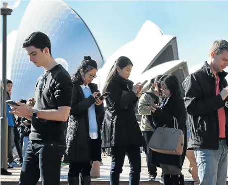  ?? Picture: AFP PHOTO ?? MAKING A ‘POKESTOP’: Dozens of people gather to play Pokémon Go in front of the Sydney Opera House, Australia