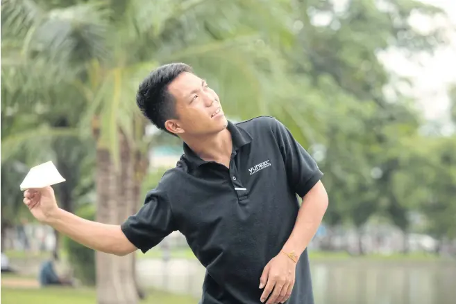  ??  ?? Mong Thongdee flies one of his paper planes in Chatuchak Park.