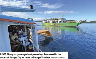  ?? ERWIN MASCARIÑAS ?? A FAST fiberglass passenger boat passes by a Roro vessel in the waters of Surigao City en route to Dinagat Province.