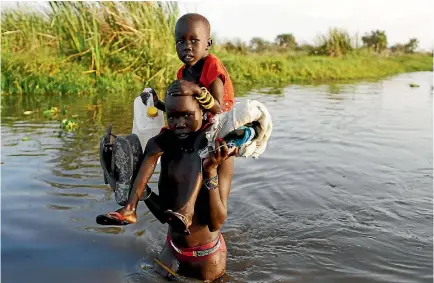  ?? PHOTO: REUTERS ?? Children cross a body of water to reach a registrati­on area prior to a food distributi­on carried out by the United Nations World Food Programme (WFP) in Thonyor, Leer state, South Sudan.