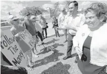  ?? WILFREDO LEE/AP ?? Rep. Joaquin Castro, D-Texas, second from right, chairman of the Congressio­nal Hispanic Caucus, and Rep. Donna Shalala, right, chat with demonstrat­ors Tuesday after their tour the Homestead Temporary Shelter for Unaccompan­ied Children.