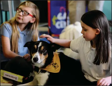  ??  ?? Langfaulds Primary pupils Marissa Johnston, P4, left, and Courtney Reid, P6, pat Skye the dog as part of supported reading