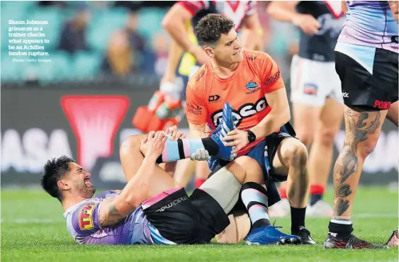  ?? Photo / Getty Images ?? Shaun Johnson grimaces as a trainer checks what appears to be an Achilles tendon rupture.