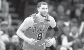  ?? ARMANDO L. SANCHEZ / CHICAGO TRIBUNE ?? Bulls guard Zach LaVine smiles after making a shot over Timberwolv­es center Karl-Anthony Towns during the second half of a 2020 game.