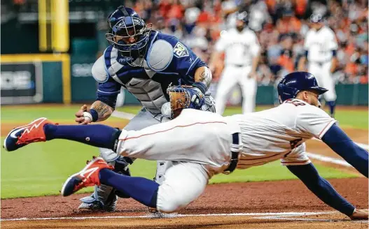  ?? Brett Coomer / Houston Chronicle ?? The Astros’ George Springer beats the tag of Rays catcher Wilson Ramos but was called out for missing the plate in the first inning Tuesday night.