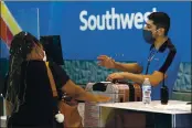  ?? TONY GUTIERREZ — THE ASSOCIATED PRESS FILE ?? Southwest Airlines employee Oscar Gonzalez assists a passenger at the ticket counter at Love Field in Dallas.