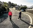  ?? BRADEN FASTIER/ STUFF ?? The eight households in Henrietta Way have had to pool together more than $20,000 to pay for road repairs at their private road. Pictured here are residents Chris Flaherty and Kirsten Rødsgaard.