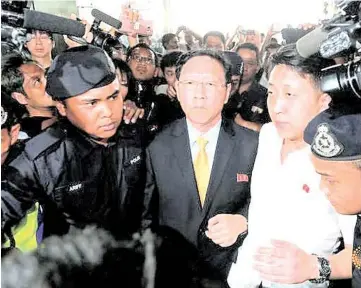  ??  ?? North Korean ambassador Kang Chol (centre) being escorted as he arrived at the Kuala Lumpur Internatio­nal Airport in Sepang before boarding a Malaysia Airlines flight out of Malaysia yesterday.
