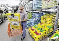  ?? STEVEN SENNE / ASSOCIATED PRESS ?? Joe Russo of Medway, Mass., puts a bag of potting soil into a cart in May while shopping at a Home Depot in Bellingham, Mass. Businesses trimmed stockpiles of goods in the spring, contributi­ng to sluggish economic growth.