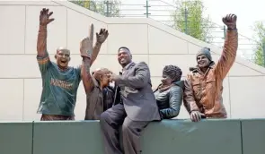  ?? USA TODAY ?? LeRoy Butler, credited with originatin­g the Lambeau Leap, was the first to pose with the Lambeau Leap sculpture at Harlan Plaza in 2014.