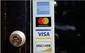  ?? STEVEN SENNE — THE ASSOCIATED PRESS FILE ?? Credit card logos are displayed on a business’s door in Cambridge, Mass.