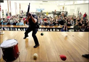  ?? NWA Democrat-Gazette/DAVID GOTTSCHALK ?? Cpl. David Faulk, student resource officer with the Prairie Grove Police Department, takes a defensive stance Tuesday as he is hit by rubber balls as an offensive move by students during an active shooter training assembly at Prairie Grove Middle...