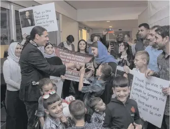  ?? DAVID LIPNOWSKI, CP ?? Liberal MP Robert-Falcon Ouellette, left, greets refugees in Winnipeg last August.