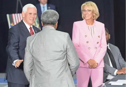  ?? MARK HOFFMAN / MILWAUKEE JOURNAL SENTINEL ?? Vice President Mike Pence, left, greets Calvin A. Lee of the the American Federation for Children, while accompanie­d by Education Secretary Betsy DeVos before a school choice roundtable discussion at the Waukesha STEM Academy in Waukesha on Tuesday. Story, Page 6A.