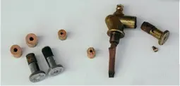  ?? ?? Above: The BSA A10’s two petrol tap plungers ready for recorking, along with another tap as an example of how the plunger with twist action lock fits to tap body.
Right: Most petrol tap plungers of the type illustrate­d are in three parts – stepped shaft, which holds the cork on its larger diameter part, and the tap knob to effect the push, pull and twist action. This locates to both parts of the larger diameter shaft section and the thinner portion which when made had its end poked through the knob and then spread into a tiny button to secure the knob firmly. To dismantle, the button end of the shaft is drilled out – but only drill deep enough to almost free the shaft from the knob, then drive out the shaft with blunt, small diameter rod punch.