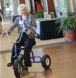  ??  ?? Fran Mainella fools around with a multipurpo­se bike made by a U.S. Play Coalition business partner.