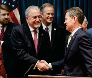  ?? AP-Bob Andres ?? Gov. Brian Kemp greets state school Superinten­dent Richard Woods as he entered his ceremonial office where he announced legislatio­n to cut five mandatory standardiz­ed tests for Georgia public school students, including four in high school, during a news conference in Atlanta on Tuesday. The Republican officials are also trying to cut the length of state tests and evaluate local tests that Georgia’s 181 school districts give to evaluate student progress.