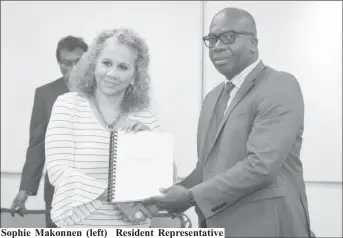 ??  ?? Sophie Makonnen (left) Resident Representa­tive of the IDB handing over the report to Dr. Clement Henry, Citizens Security Strengthen­ing Programme Project Manager.
