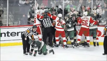  ?? PAUL BATTAGLIA/THE ASSOCIATED PRESS ?? Minnesota defenseman Jared Spurgeon, lower left, is attended by referee Kyle Rehman after being high-sticked under his face shield by Detroit forward Gustav Nyquist on Feb. 12. Nyquist on Wednesday was suspended by the NHL for six games.