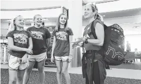  ?? STAFF PHOTO BY TIM BARBER ?? Liz Baker, right, a paralympia­n from Signal Mountain, enjoys a moment with her Chattanoog­a Track Club members she mentors upon arrival at the Chattanoog­a Metropolit­an Airport on Wednesday. From left are Emily Thomson, Anna Thomson Taylor Milliron.
