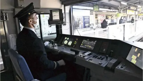  ?? Yomiuri Shimbun file photo ?? A driver sits at the controls of a Yamanote Line train during an automated driving trial in February.