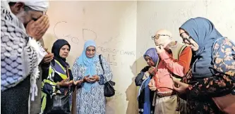  ?? JIKELO African News Agency (ANA) PHANDO ?? THE family of Imam Abdullah Haron are joined by members of the MJC, praying inside the Maitland police cell where he died. The family broke down and cried as they entered the place where their father died 53 years ago, after being in detention for 123 days. |