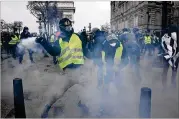  ?? JEFF J MITCHELL/GETTY IMAGES ?? A protester throws a tear gas canister during a demonstrat­ion Saturday in Paris over taxes and rising fuel costs.