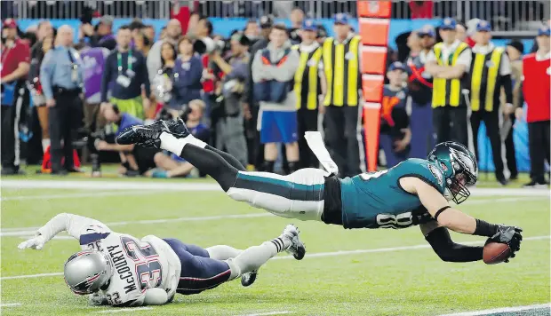  ?? FRANK FRANKLIN II/ THE ASSOCIATED PRESS ?? Philadelph­ia tight end Zach Ertz dives into the end zone over New England free safety Devin McCourty for the game-winning touchdown.