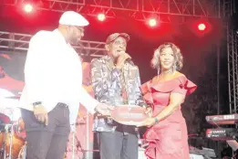  ?? ?? Jamaica Reggae Industry Associatio­n President Ewan Simpson (left) and June Issacs (right) present Lloyd Parks with a plaque on behalf of the Gregory Isaacs Foundation.