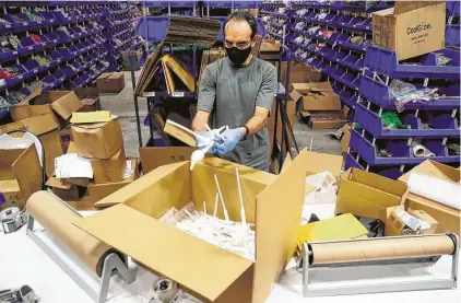  ?? Photos by Brett Coomer / Staff photograph­er ?? Mohsin Ebrahim packs sanitizer pumps into a box for delivery at Ionized LLC, a Sugar Land glow stick manufactur­er.