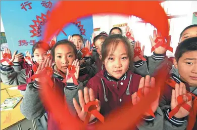  ?? ZHANG ZHENGYOU / FOR CHINA DAILY ?? Elementary school students in Donghai county in Jiangsu province crafted red ribbons as part of an HIV/AIDS prevention campaign on Tuesday.