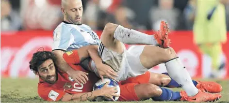 ?? FOTO: AFP ?? ►► Jorge Valdivia recibe la áspera marca de Javier Mascherano.