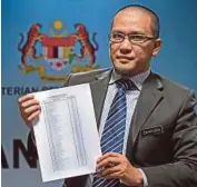  ?? [FOTO BERNAMA] ?? Zahirudin menunjukka­n senarai bekas guru pencarum KWSG.