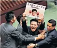  ??  ?? A protester targets Carrie Lam, who banned demonstrat­ors wearing face masks
