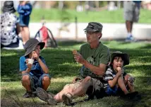  ??  ?? Richard Monk with his sons Thomas, left, and Aidyn enjoy a cool break on the banks of the Avon River.