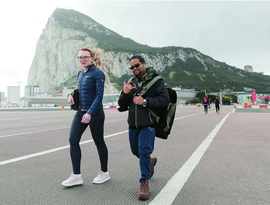  ?? REUTERS ?? Dos gibraltare­ños pasean ayer por los alrededore­s del Peñón ya sin llevar la mascarilla que deja de ser obligatori­a al aire libre