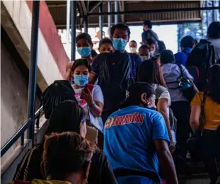 ?? PHOTOGRAPH BY YUMMIE DINGDING FOR THE DAILY TRIBUNE @tribunephl_yumi ?? WITH alert Level 1 maintained in Metro Manila, commuters crowd the stairway of the EDSA Guadalupe MRT rail station unmindful of social distancing protocols.