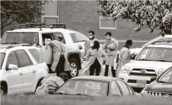  ?? Erin Bormett / Associated Press ?? Health care workers gather patient informatio­n from cars in line at a coronaviru­s testing site for Smithfield employees in a high school parking lot Monday in Sioux Falls, S.D.